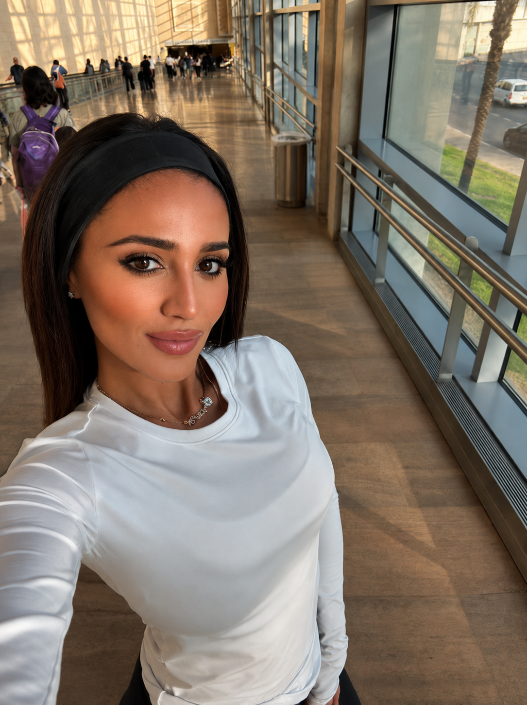 A woman in white standing inside the airport after arriving in Israel